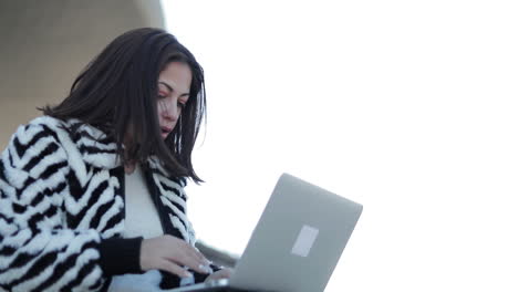 Slow-motion-shot-of-concentrated-young-woman-typing-on-laptop